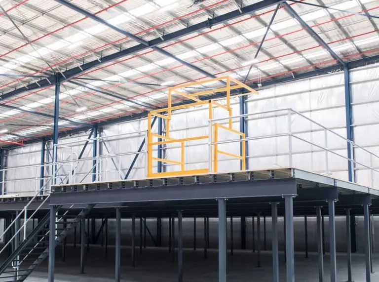 Steel mezzanine floor with a yellow pallet gate and edge protection