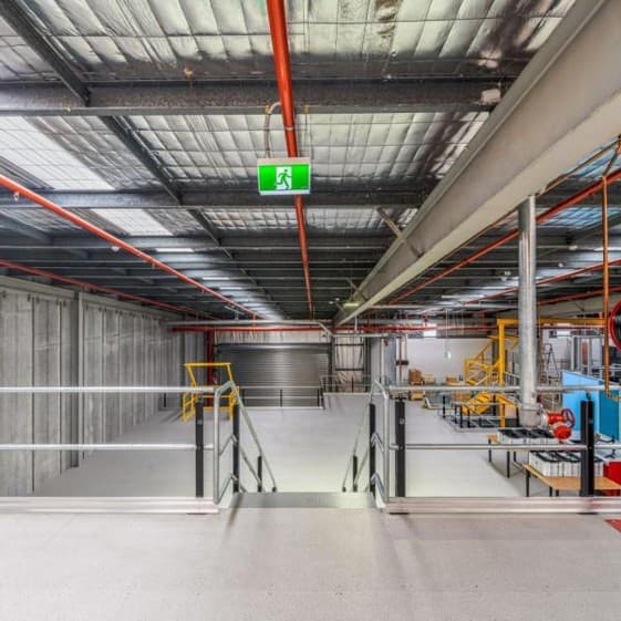 Mezzanine with overhead sprinkler pipework and an illuminated exit sign
