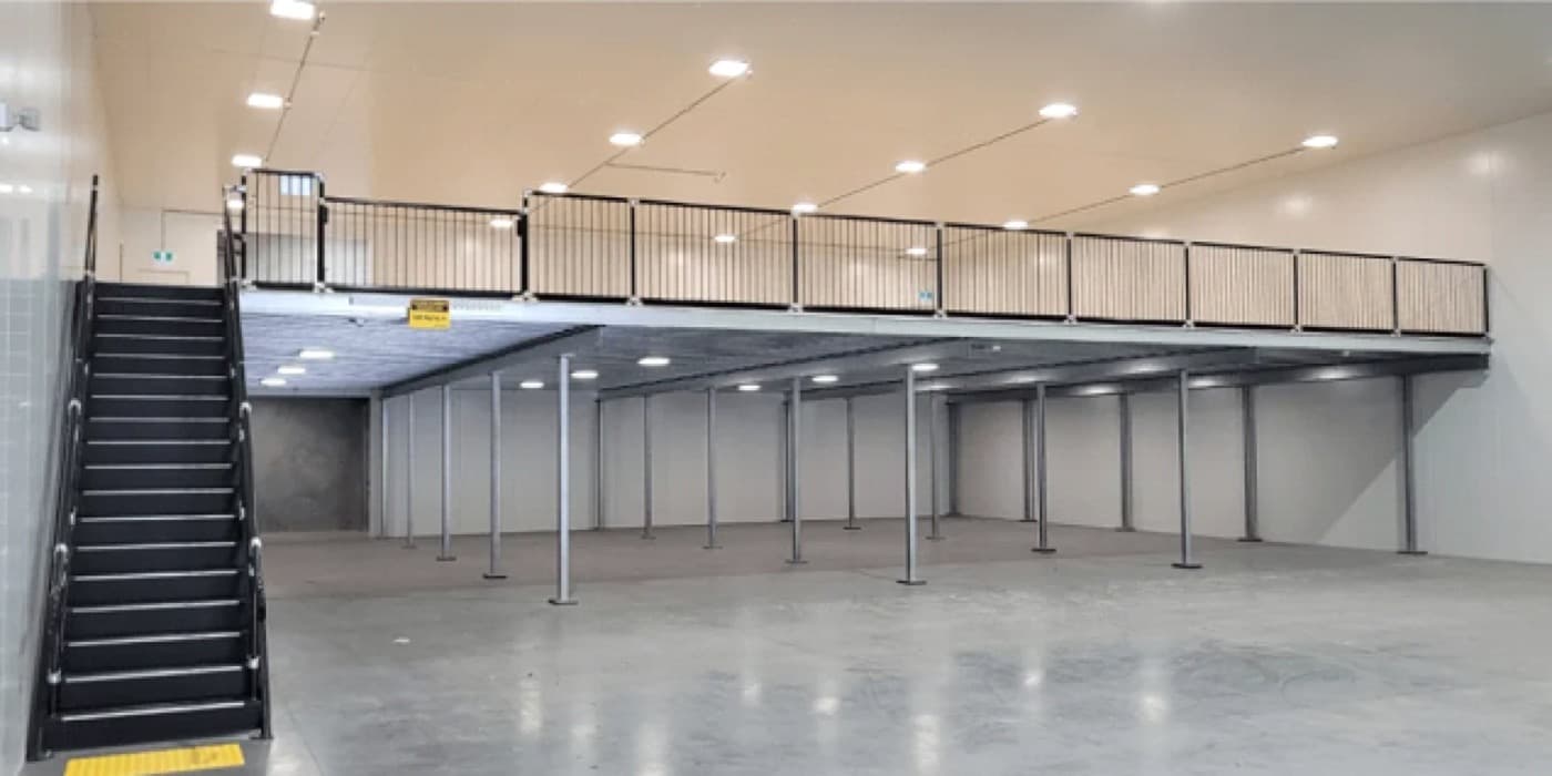Clean steel mezzanine floor with staircase installed by Altivo