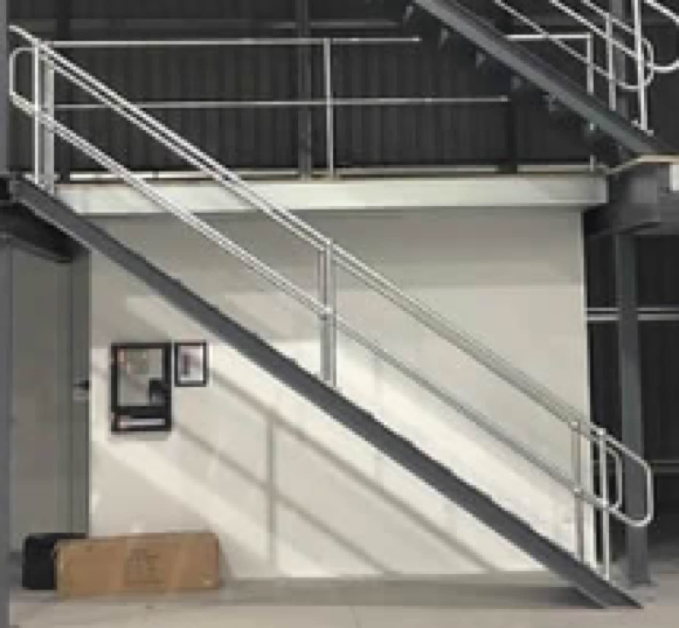 Steel stairs being fitted to a mezzanine floor in a warehouse