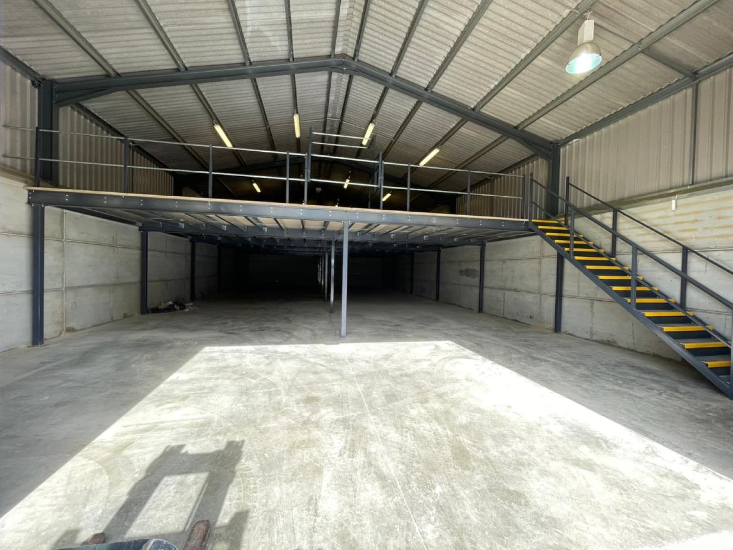 Steel mezzanine storage floor in use above a warehouse receiving area